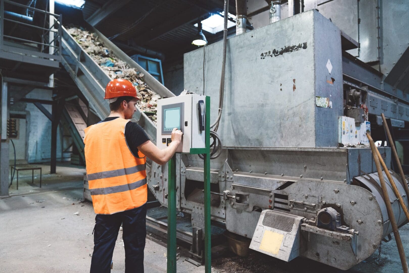 Worker operating machinery in recycling facility.